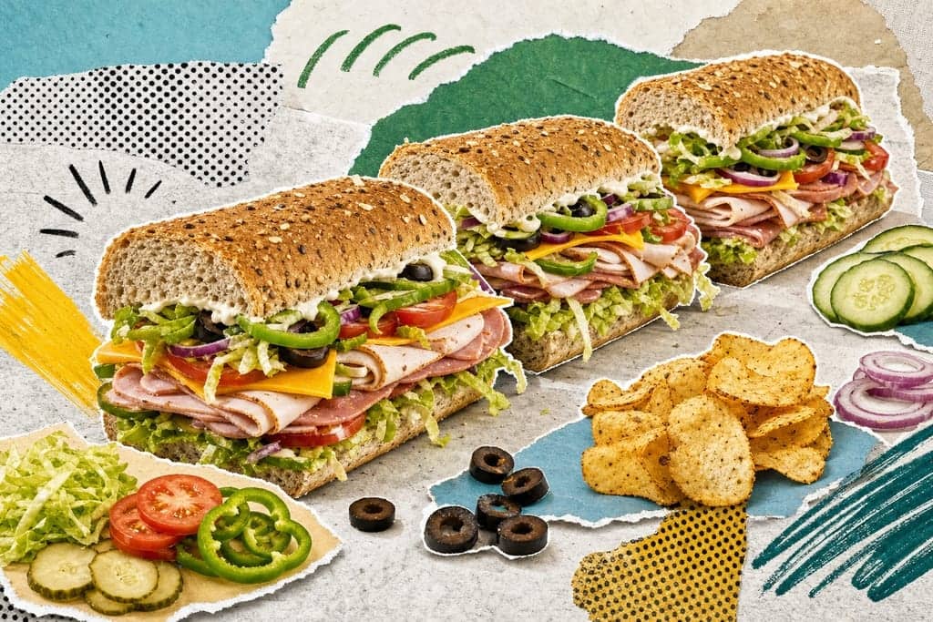 Editorial mixed-media collage of a long Subway-style veggie-loaded sub sandwich cut into three thick sections as the unmistakable central subject, viewed from a dramatic diagonal side angle slightly above counter height, the pieces staggered in a descending line across the frame with fillings spilling visibly forward to showcase layers of multigrain bread, sliced turkey, ham, cheddar, shredded lettuce, tomato, cucumber, red onion, green pepper rings, black olives, pickles, and zigzags of creamy sauce, surrounded by a few neatly separated topping ingredients and a small pile of baked chips as secondary accents, set on a cool pale stone prep surface inspired by a clean sandwich assembly counter, crisp early-lunch daylight with a fresh energetic atmosphere, bright appetizing palette of leafy greens, tomato red, mustard yellow, soft beige bread and clean aqua-blue paper shadows, editorial mixed-media collage, cut-out photographic elements with rough scissor edges layered over torn paper, halftone scraps, bold flat colour shapes and hand-drawn marks, visible glue-stick texture and paper grain, playful magazine composition, no readable text, no characters, no humans.