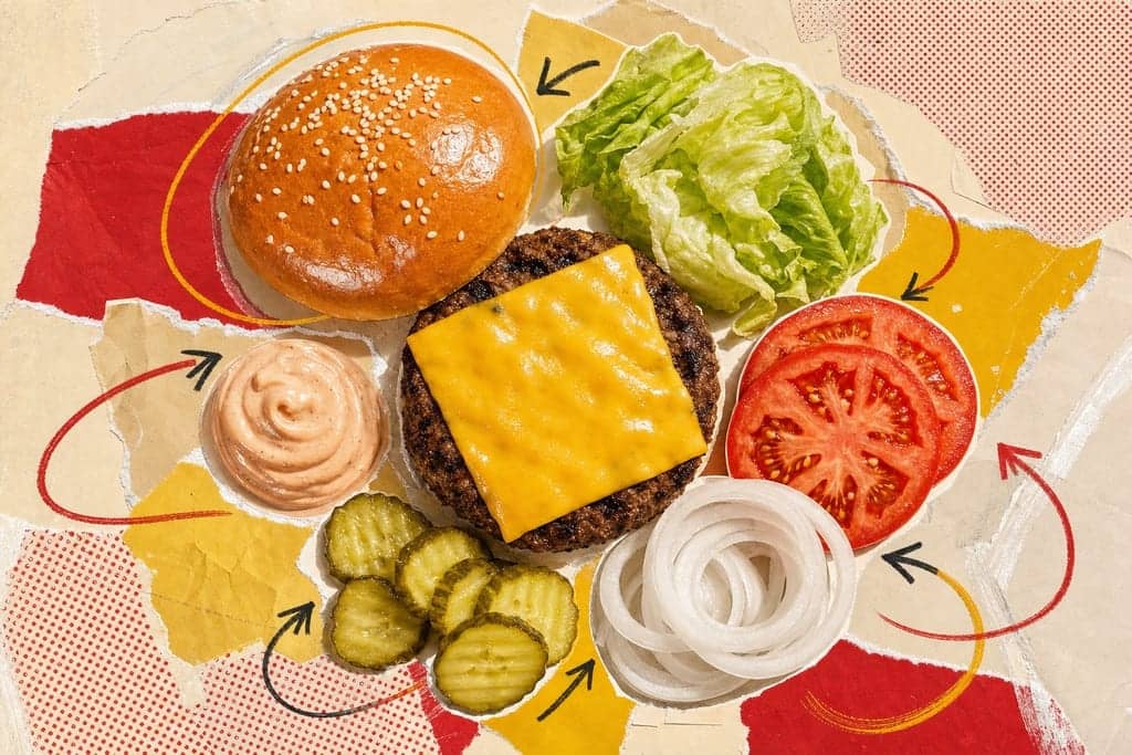 Editorial mixed-media collage of an In-N-Out-style cheeseburger nutrition deconstruction as the unmistakable central subject, viewed from a dramatic straight-down overhead angle, with the burger ingredients separated and arranged in a precise radial composition like a food-analysis study: glossy golden bun top with sesame seeds, melted American cheese slice draped over a freshly grilled beef patty, crisp green lettuce, thick tomato slices, translucent white onion rings, pickle chips, and a small swirl of creamy burger sauce, each element slightly overlapping but clearly distinct on a layered background of torn parchment, pale mustard paper, faded red paper scraps, and soft cream halftone textures; bold flat color blocks frame the ingredients with energetic hand-drawn circles and arrows that contain no text, visible glue-stick streaks and paper grain adding tactile depth; bright California drive-in atmosphere at sunny late afternoon with warm golden highlights, soft shadows, and a clean appetizing yet analytical mood, vibrant red-yellow-cream-green palette, no characters, no humans, no text.